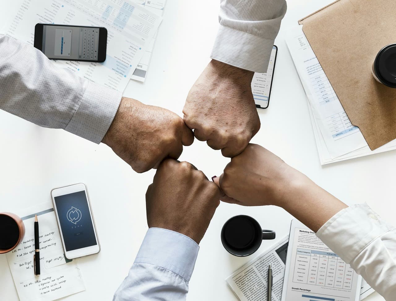 Personas uniendo sus manos como símbolo de colaboración